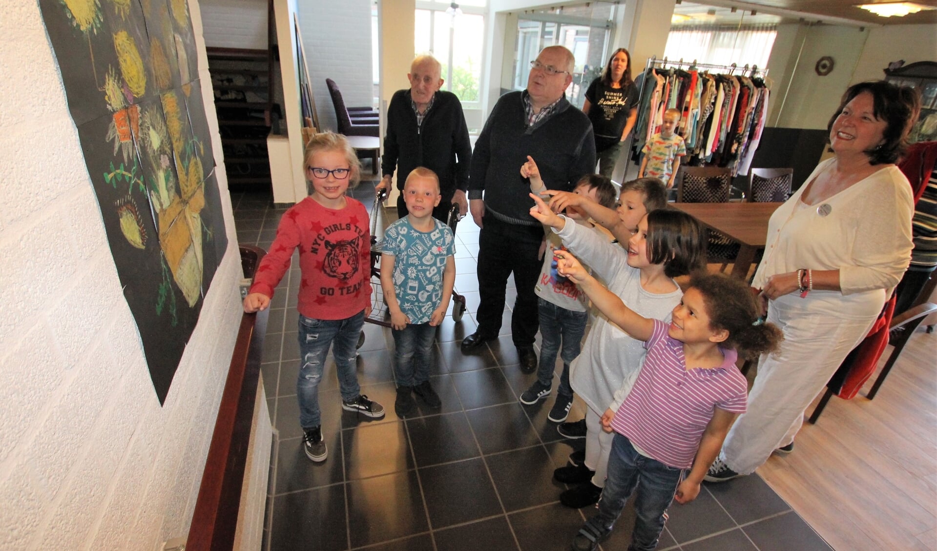 • Leerlingen van obs Het Schateiland laten bewoners van De Breeje Hendrick hun kunstwerken zien. 