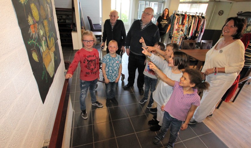 • Leerlingen van obs Het Schateiland laten bewoners van De Breeje Hendrick hun kunstwerken zien.