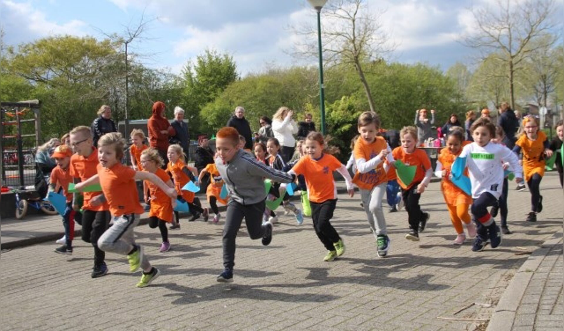 Kinderen rennen zo hard mogelijk tijdens de Koningsrun. Met hun gesponsorde rondjes zamelen ze geld in voor het goede doel en voor de verdere inrichting van hun nieuwe schoolplein. (Foto: Lysette Verwegen)