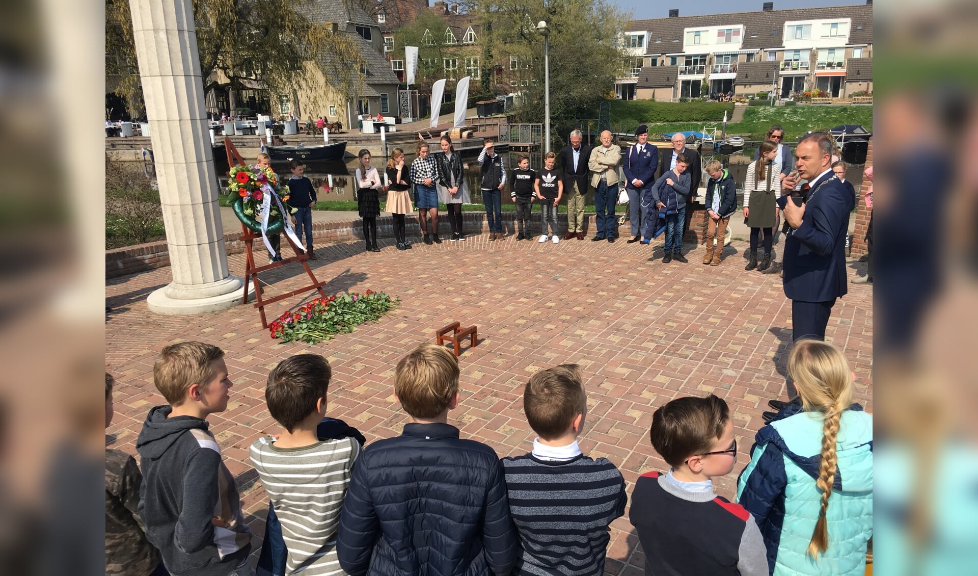 • Burgemeester Paans (rechts) spreekt de kinderen toe na afloop van de ceremonie.