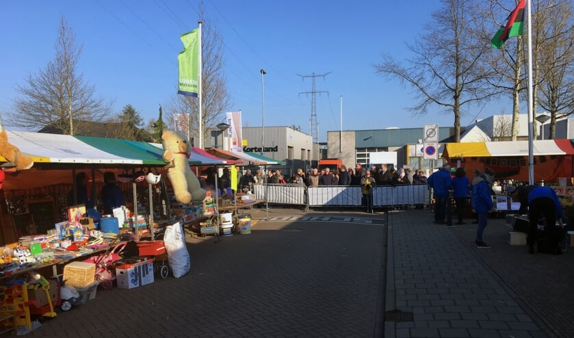 • Wachten bij de dranghekken voor de start van de rommelmarkt.