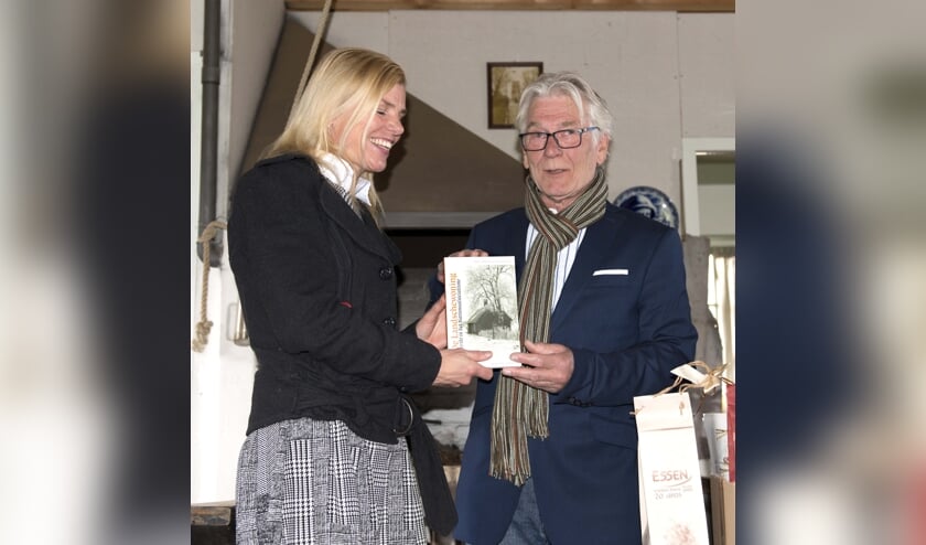 Paula Jorritsma krijgt uit handen van Bert van Straten het eerste exemplaar van 'De Landschewoning'.
