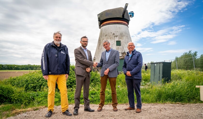• Arjan Kraijo (links) en Teus van Gelder schudden elkaar de hand bij de Souburghse molen.