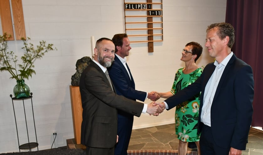 • Predikanten en kerkbestuurders schudden elkaar de hand.