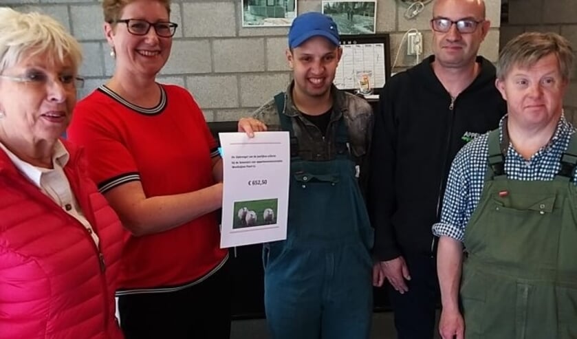 De bewoners van de Westluijnse Poort overhandigen cheque aan de clienten van 's Heerenloo.