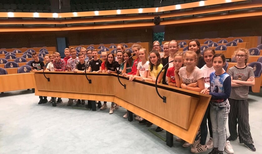 Groep 8 poseert voor de interruptiemicrofoons in de Tweede Kamer.