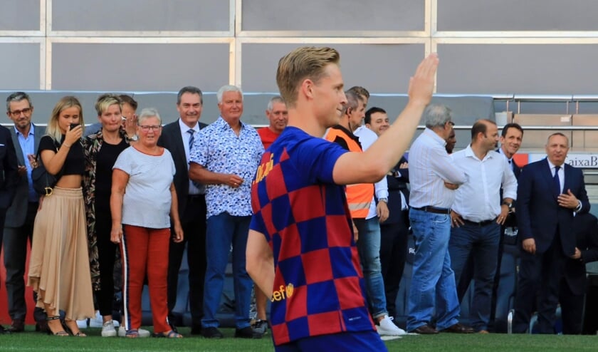 • Frenkie zwaait naar het publiek in Camp Nou; op de achtergrond pinkt zijn familie een traantje weg.