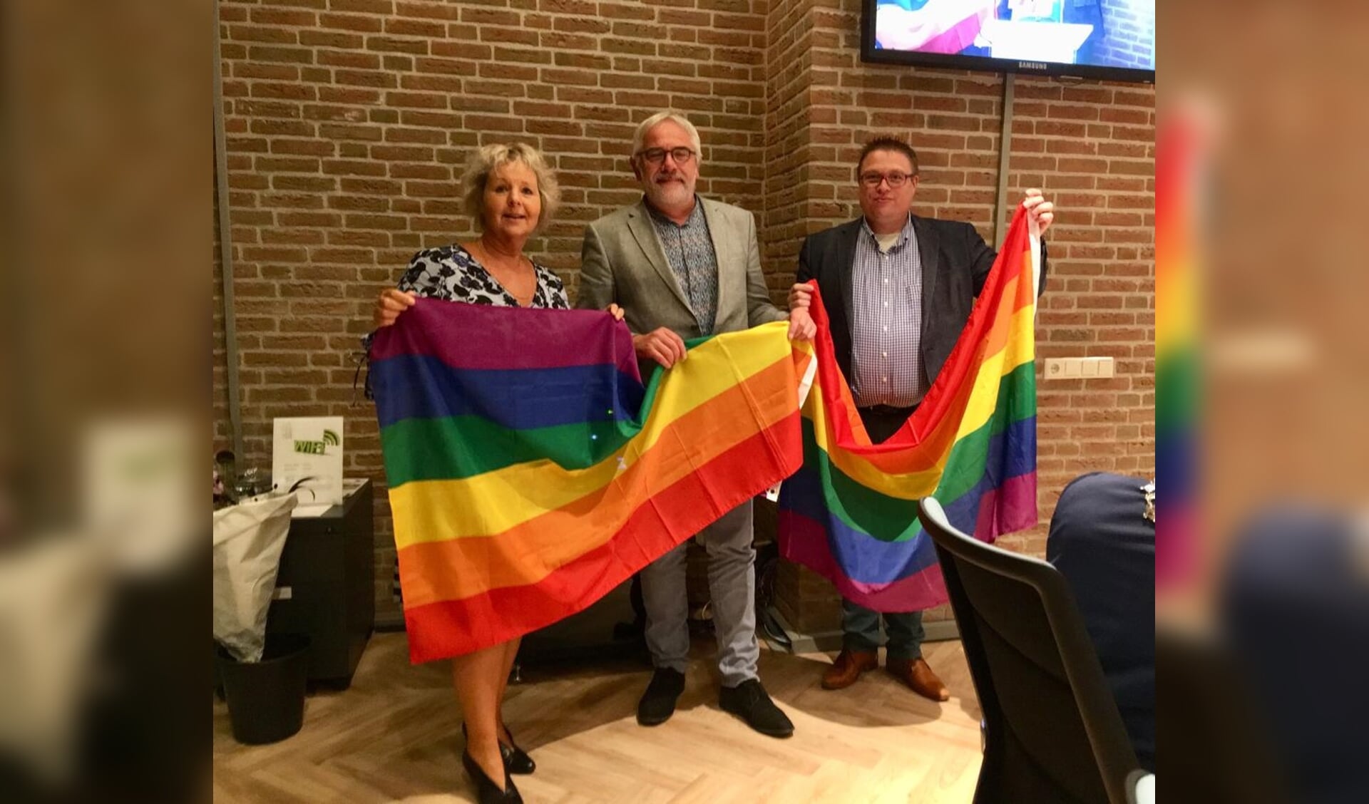 • Jantine Dijkstra en Joop van Montfoort overhandigden Cees Taal (midden) de vlaggen.  