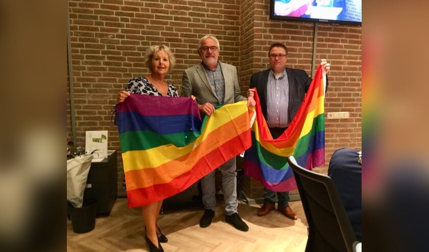 • Jantine Dijkstra en Joop van Montfoort overhandigden Cees Taal (midden) de vlaggen.