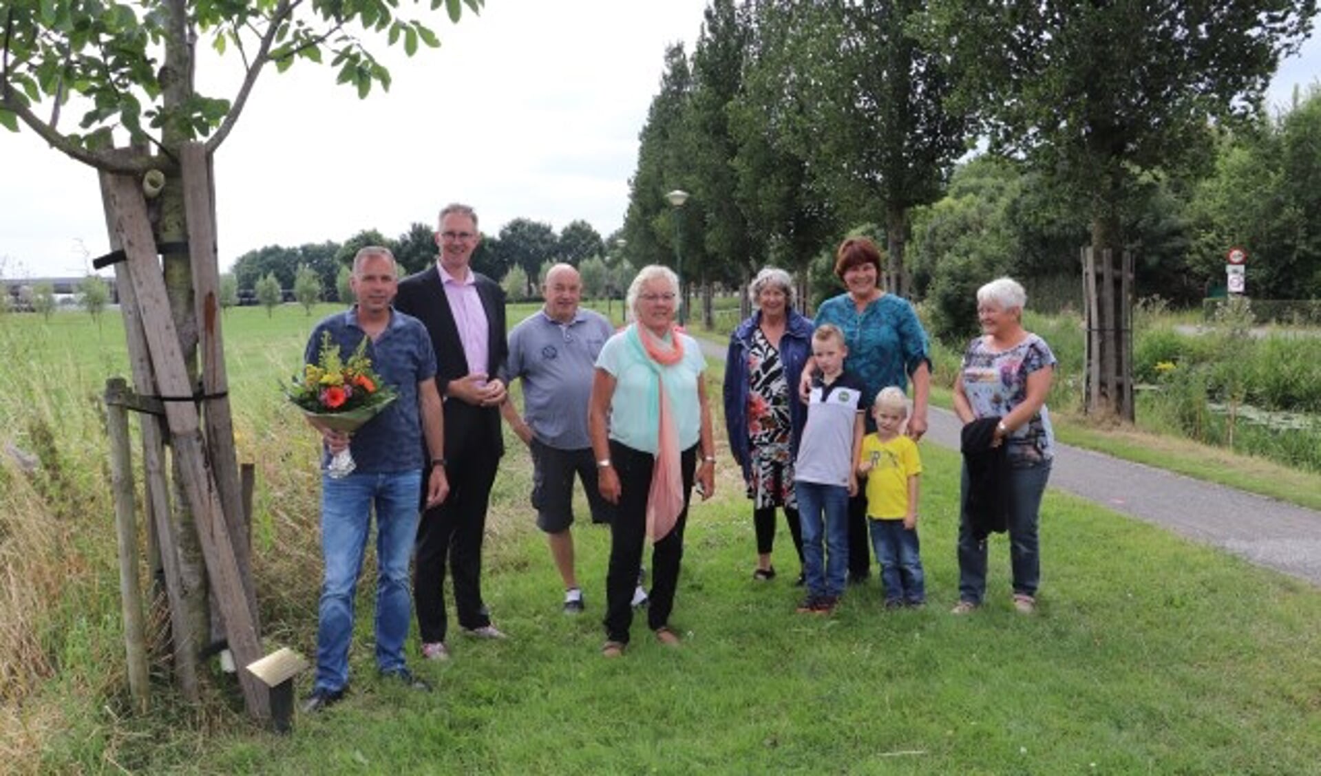 Links initiatiefnemer de heer Floris de With naast wethouder Gerrit Spelt en andere inwoners bij de walnotenboom, waaronder Dieny Scheffer. (Foto: gemeente Lopik)