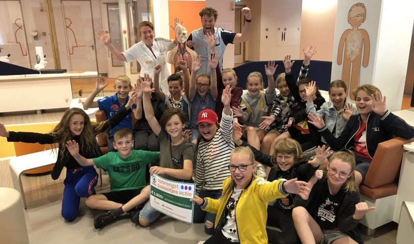 Alle kinderen van groep 7 CBS Het Kompas Vuren met dokter Natasja Dors en meester Daan op de achtergrond