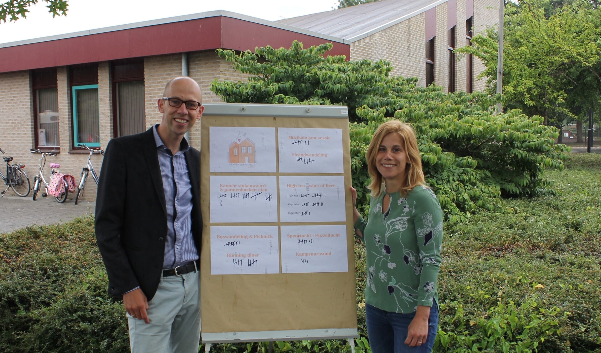 • Rik Meijer en Marion van der Ven bij het bord waarop gemeenteleden ideeën konden opschrijven voor het gemeenteproject.