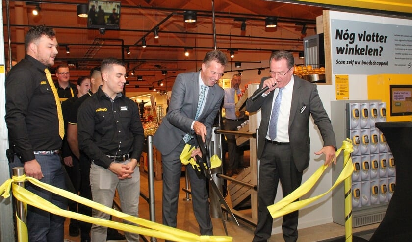 • Wethouder Paans knipt het lint door, rechts filiaalmanager Ernst Venderbos.
