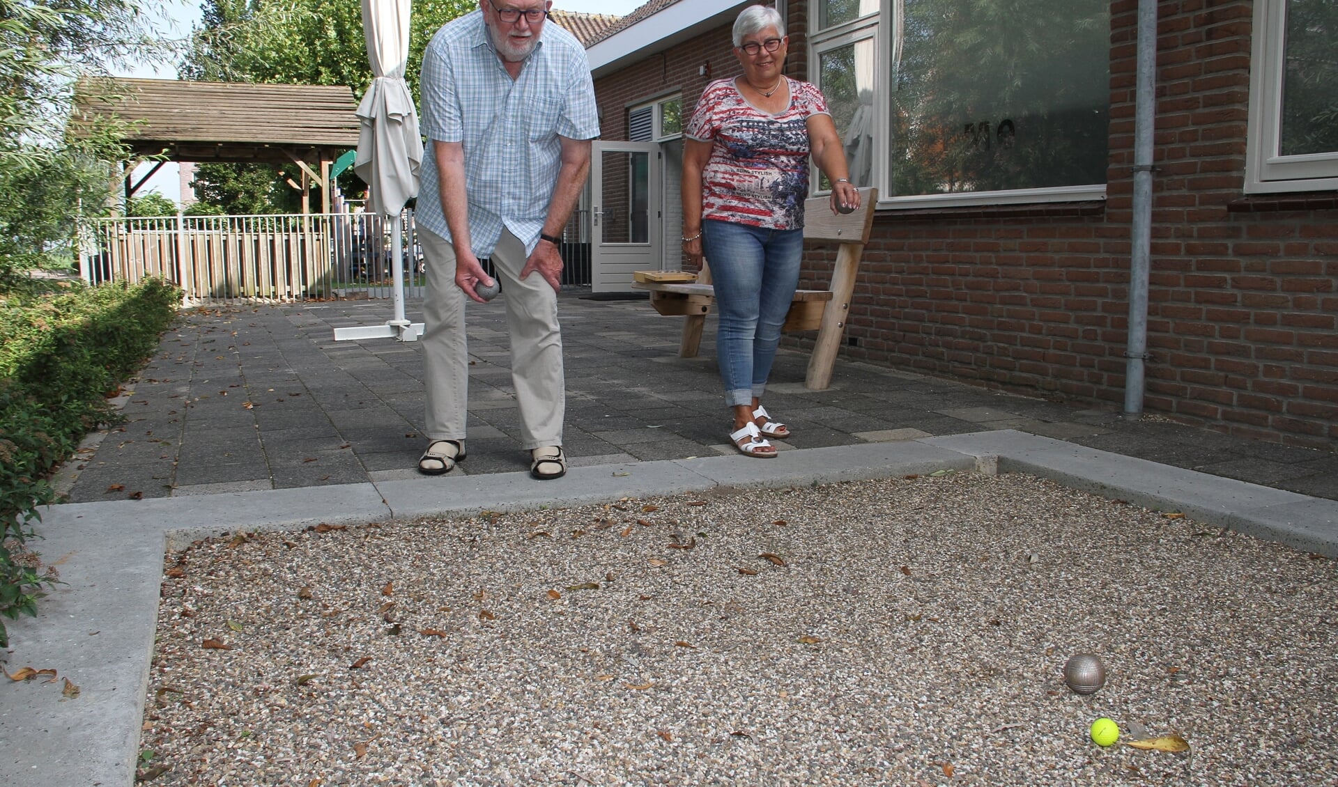 • Marius en Anie werpen een balletje op de baan achter het verenigingsgebouw.