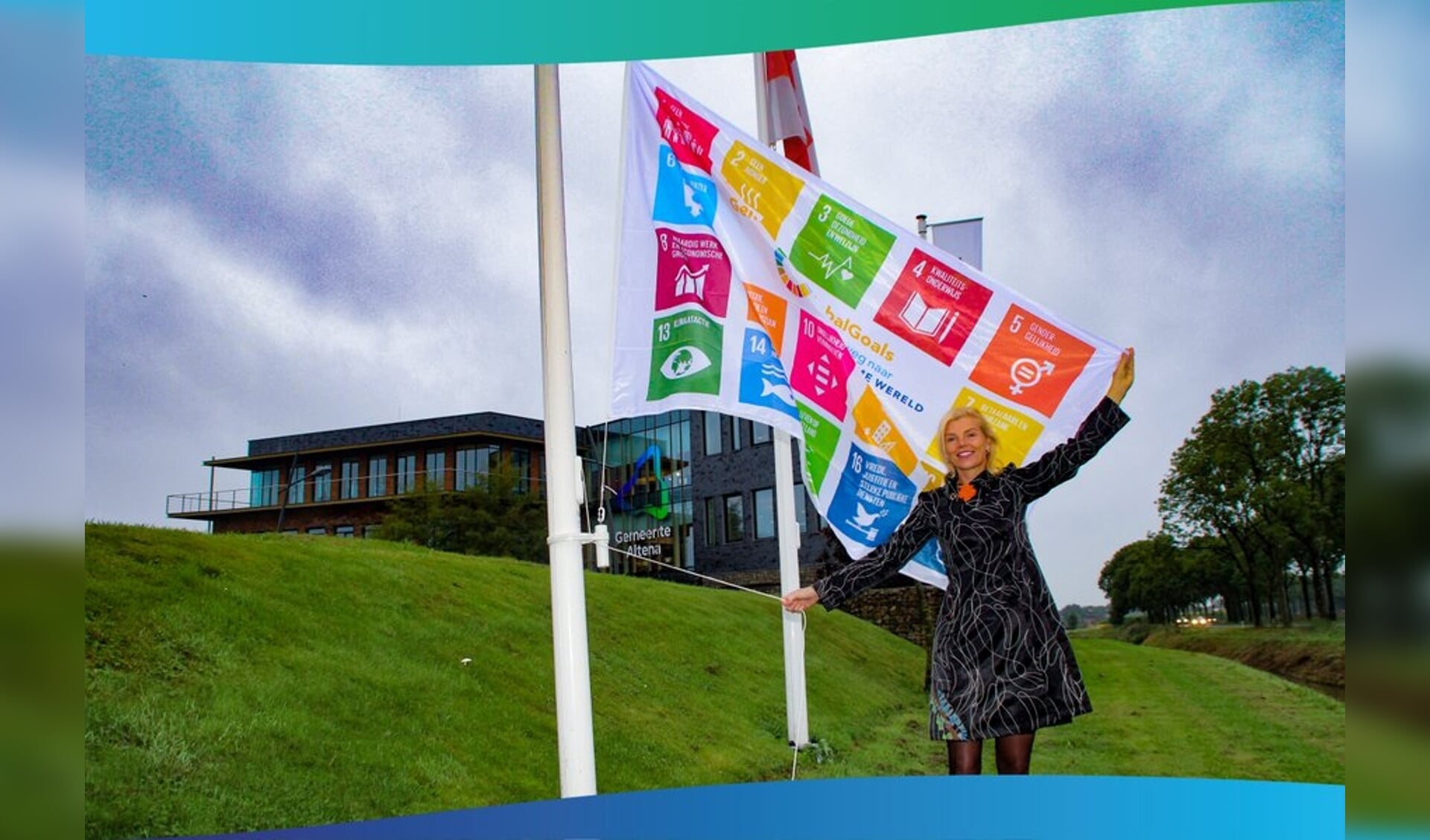 Wethouder Paula Jorritsma hijst de Global Goals-vlag voor het gemeentehuis in Almkerk.