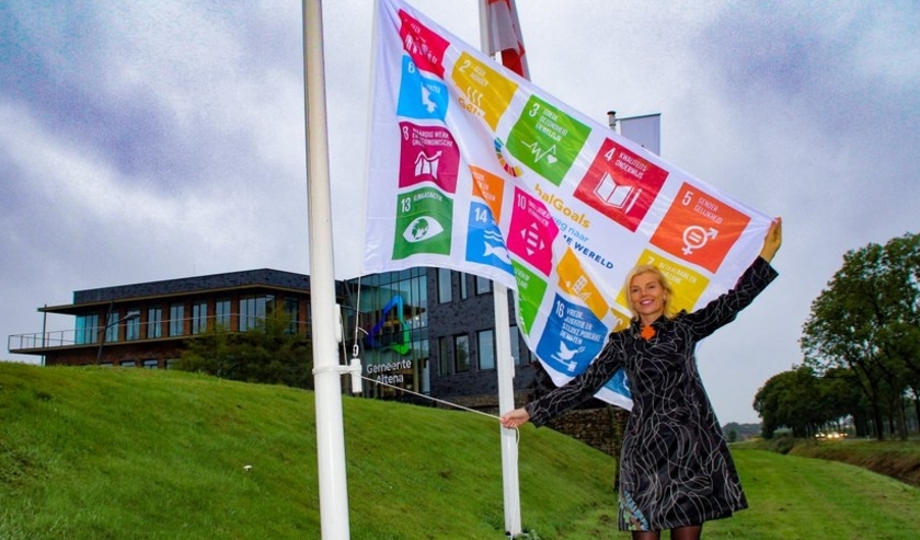 Wethouder Paula Jorritsma hijst de Global Goals-vlag voor het gemeentehuis in Almkerk.