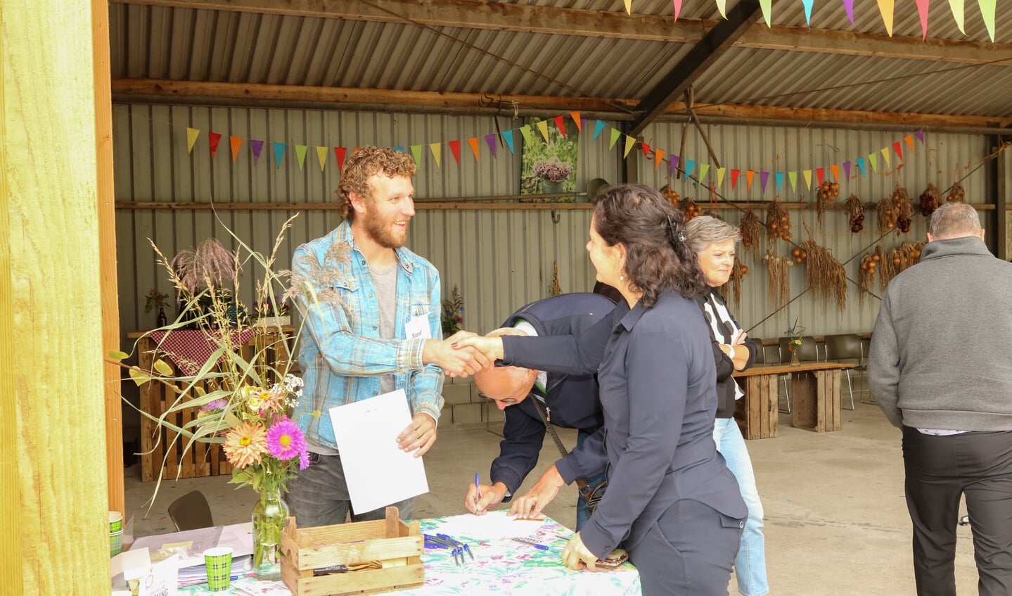 • Biologisch-dynamische boer René Bor (links) overhandigt een envelop met pas aan een klant.