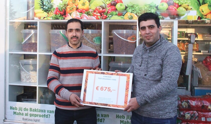 • Rateb (rechts) overhandigt de cheque aan Mohammed.