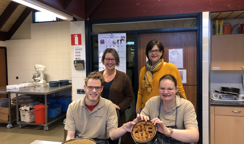 • Barbara van der Meer (l) en Mariëlla van Heck met de bakkers van De Harmonika. Mantelzorgers kunnen een gratis appeltaartje aanvragen bij Welzijn Bommelerwaard.