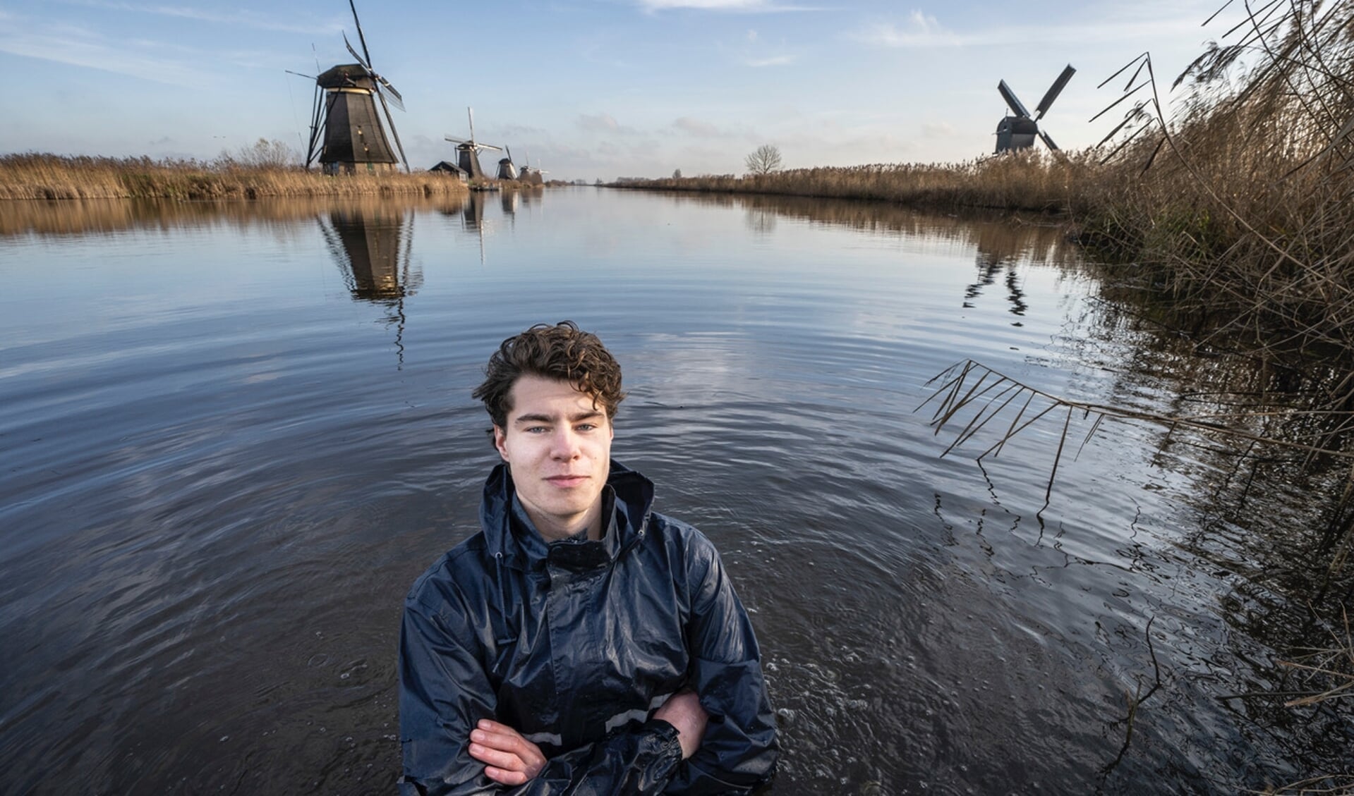 • Bart van den Sande poseert in het koude water bij Kinderdijk. 'Hoe communiceer je klimaatverandering?'
