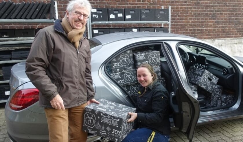 Sharon van Jumbo Aarnoudse overhandigt een pakket aan Ton van der Made van Vluchtelingenwerk.