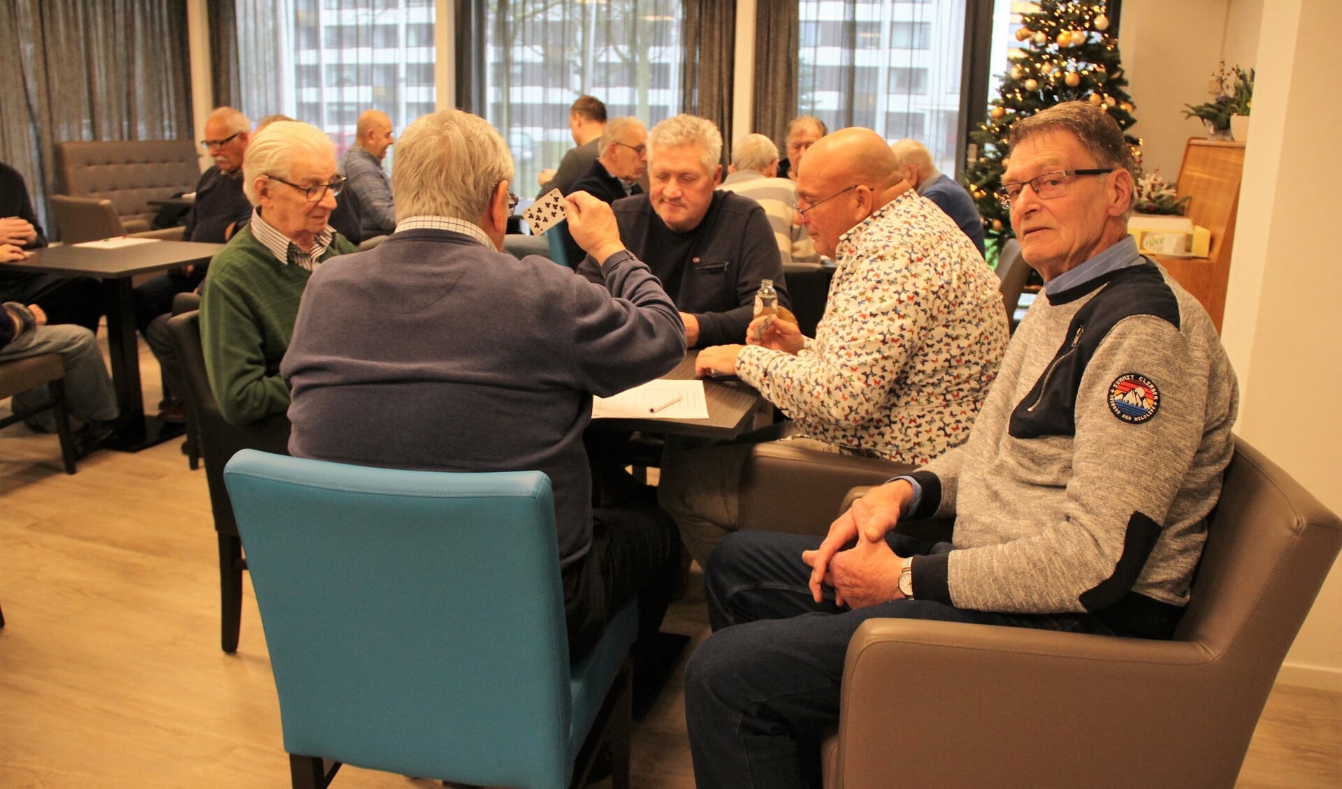 • Henk de Groot (rechts) bij een groepje klaverjassende senioren. 