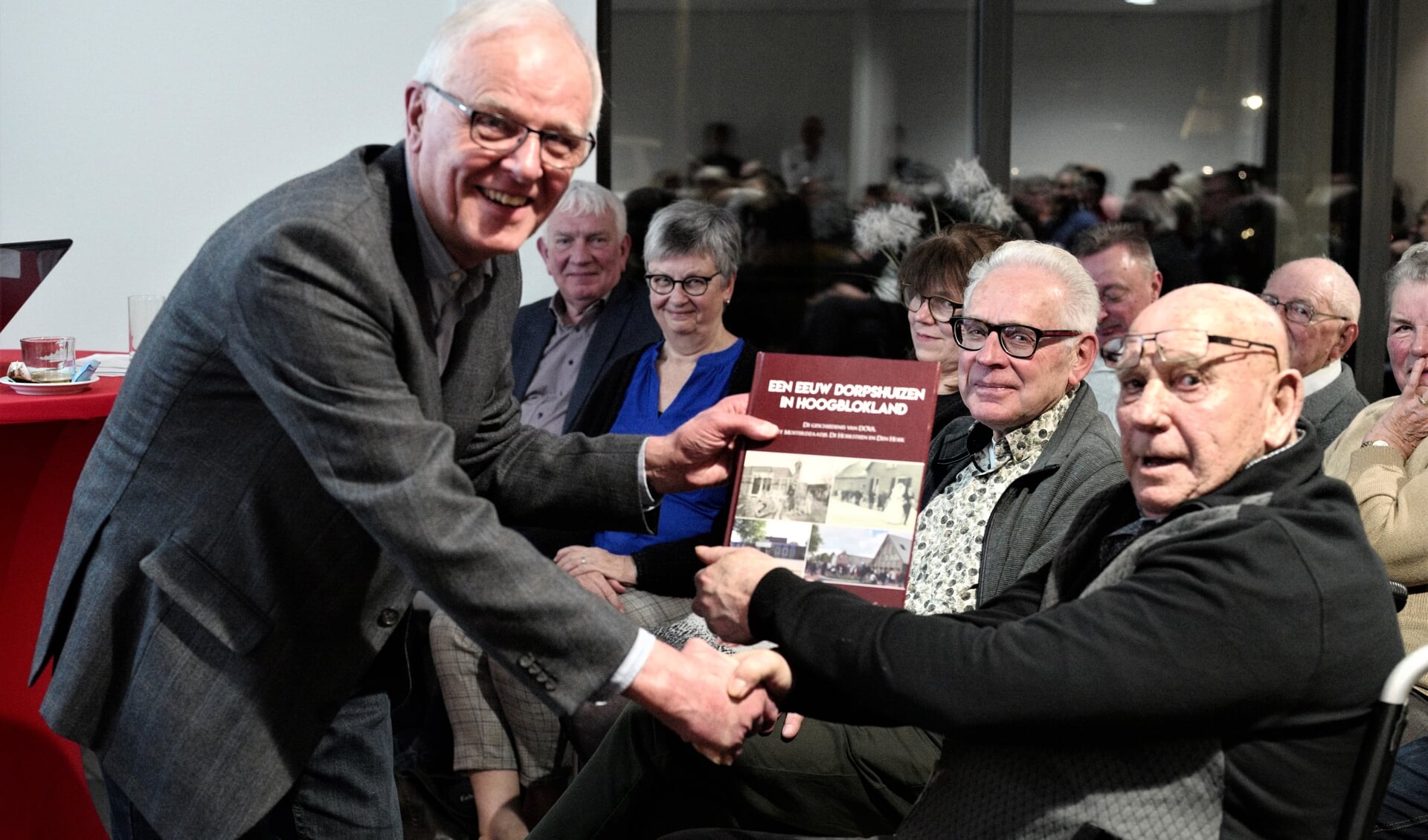 • Voorzitter Peter Baan (links) overhandigt het eerste exemplaar aan Gerrit Vonk.