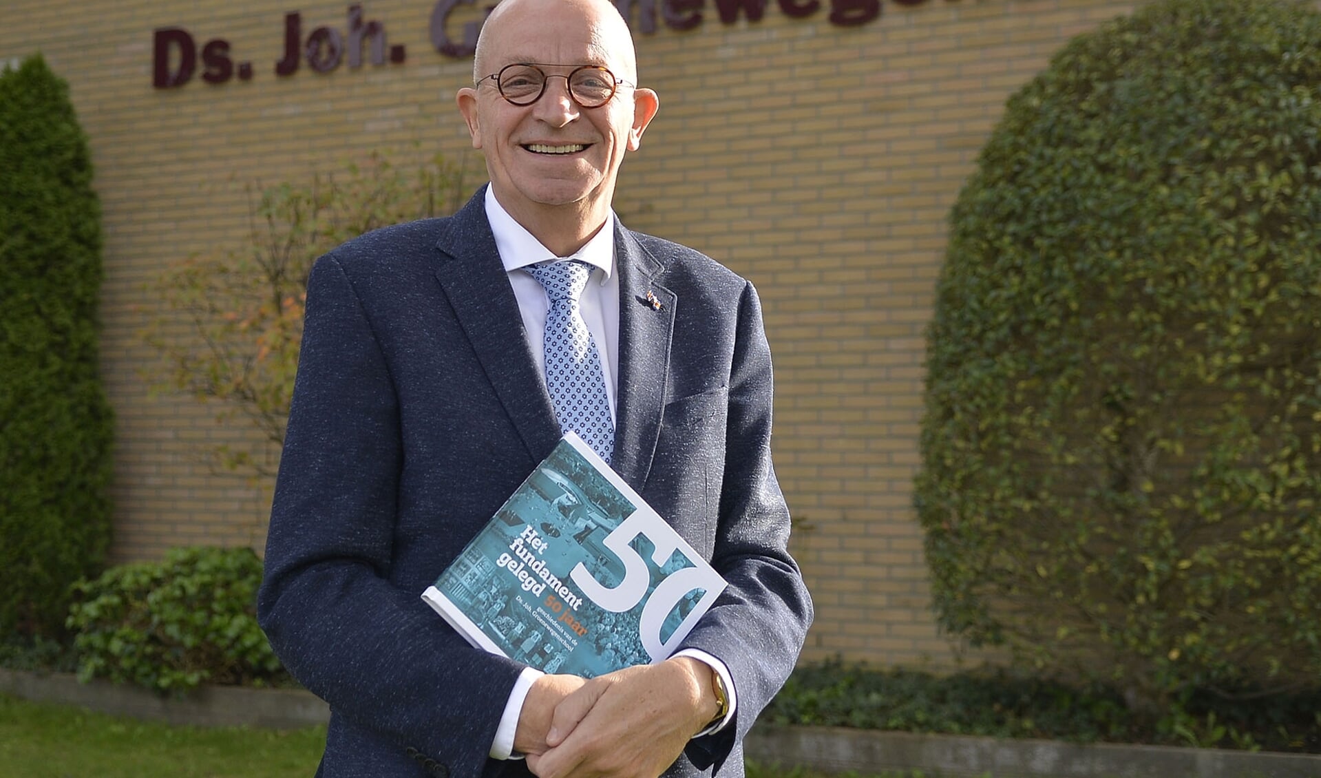 Schooldirecteur Ad Geuze met het jubileumboek.