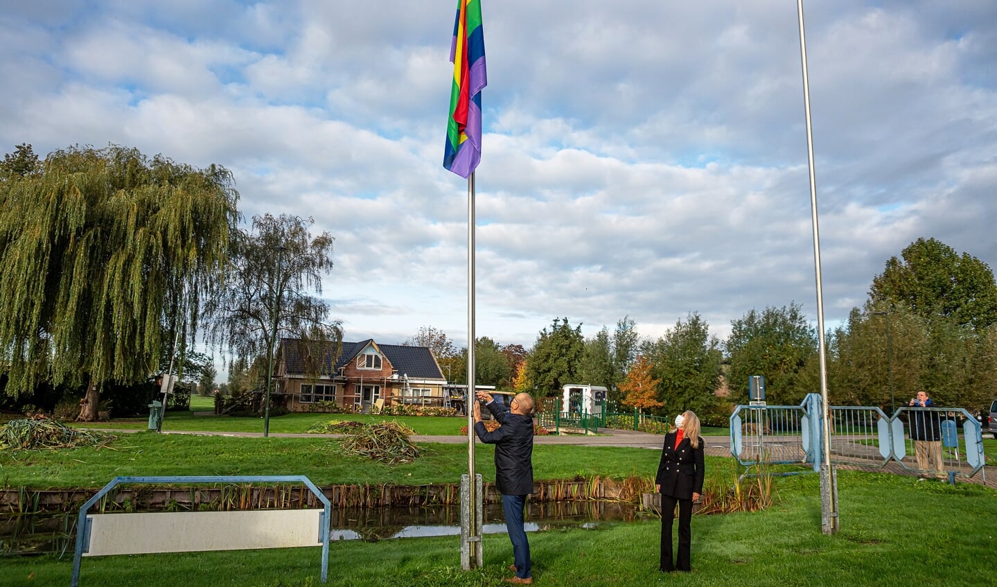 • Wethouder Lanser bij het hijsen van de regenboogvlag.