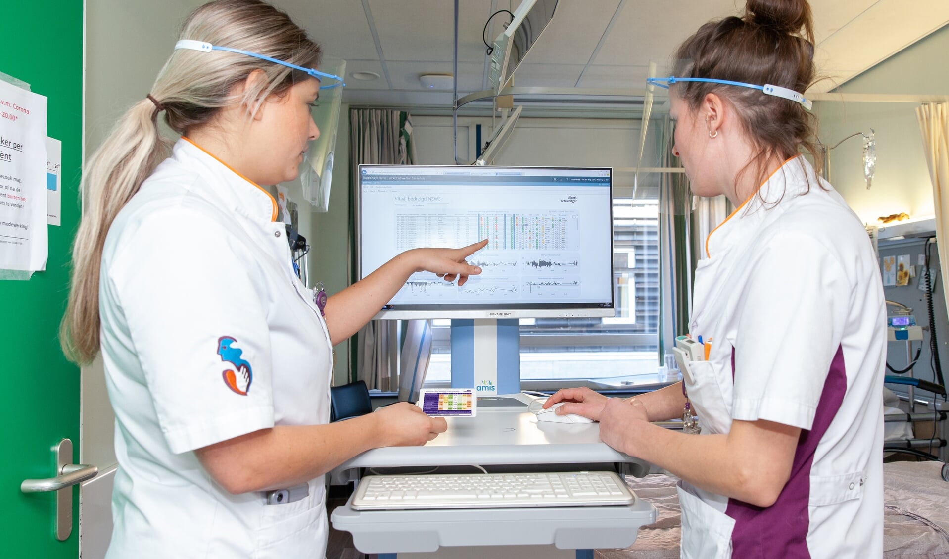 • Arts-assistent Shelly van Nieuwkasteele (links) en verpleegkundige Carla Groenendijk bekijken de risicoprofielen van alle op dat moment opgenomen patiënten op de afdeling.
