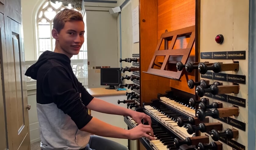 • Arthur de Jong achter het kerkorgel van de Grote Kerk van Tholen.