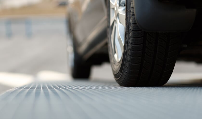 <p>Dark automobile standing on steel floor view from below. Car parking problems, motor show or exhibition, winter season tires, customer purpose loan, vehicles official checkup or examination concept</p>