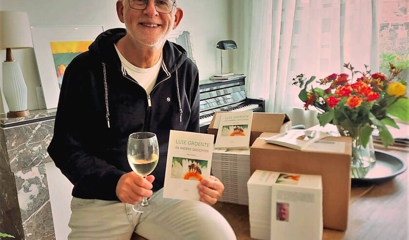 <p>Hans Erkens met zijn dichtbundel.</p>