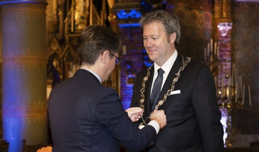 <p>Danny de Vries kreeg maandag in de Sint Fransiscuskerk de ambtsketen omgehangen door zijn echtgenoot Martijn. Foto: Aschwin Snel</p>
