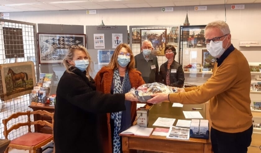 <p>Lex van Wijk (r), voorzitter van Stadsmuseum De Knoperij begroet de 1000e bezoeker en verrast haar met een Montfoort pakket. Foto: Peter Versloot </p>