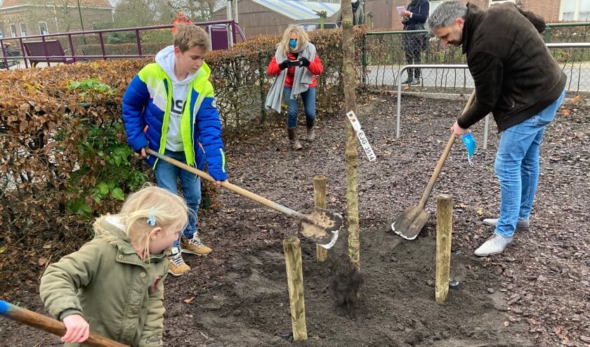 <p>• Pien en Jorey helpen de wethouder bij het planten van de boom.</p>