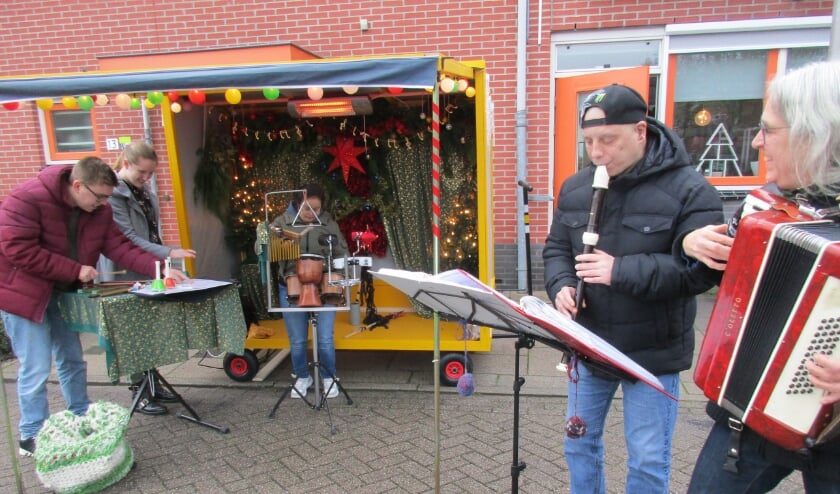 • Marian Verdonk op accordeon (r) begeleidt cliënten van de Lingebolder bij de muziekkar in Kerstsfeer.