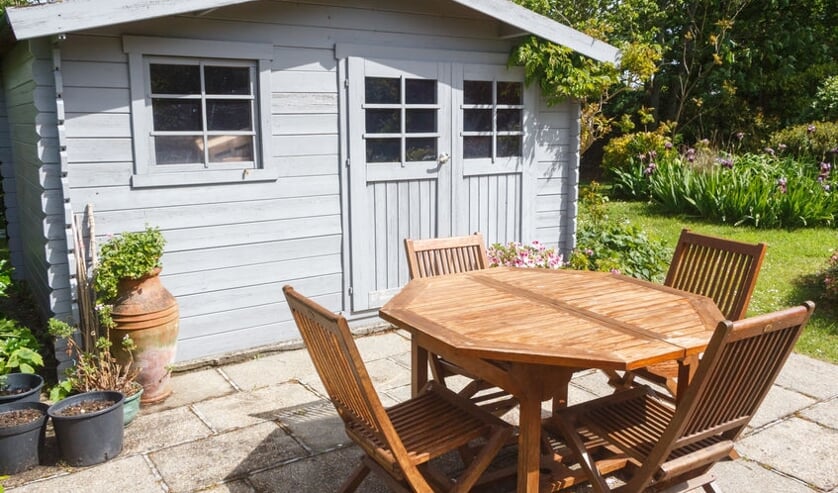 Shed with terrace and garden furniture in a garden during spring