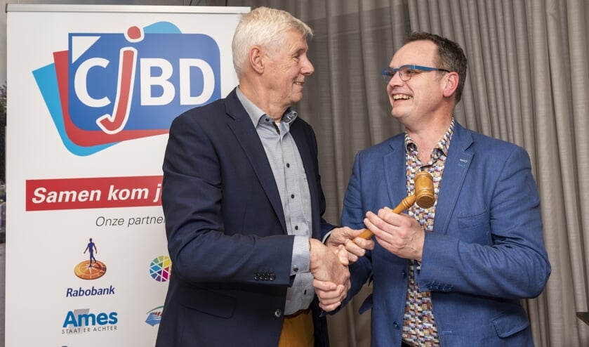 • Harry Eskes (links) draagt met de voorzittershamer zijn taken over aan Johan den Houter.