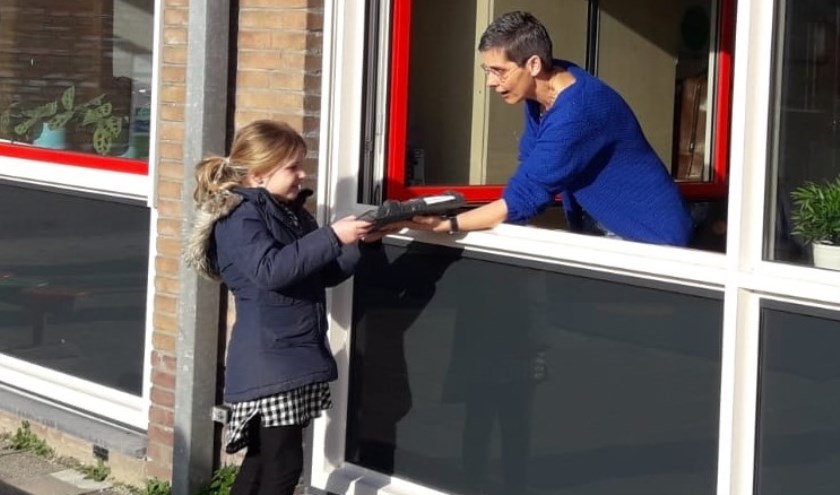• Door het open raam kregen alle leerlingen van De Ark in Vianen het (t)huiswerk overhandigd.