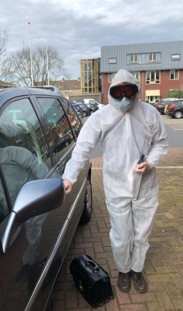 • Huisarts Dick Kruijthoff, gehuld in de beschermende kleding waarmee hij naar patiënten gaat die wellicht met corona besmet zijn.