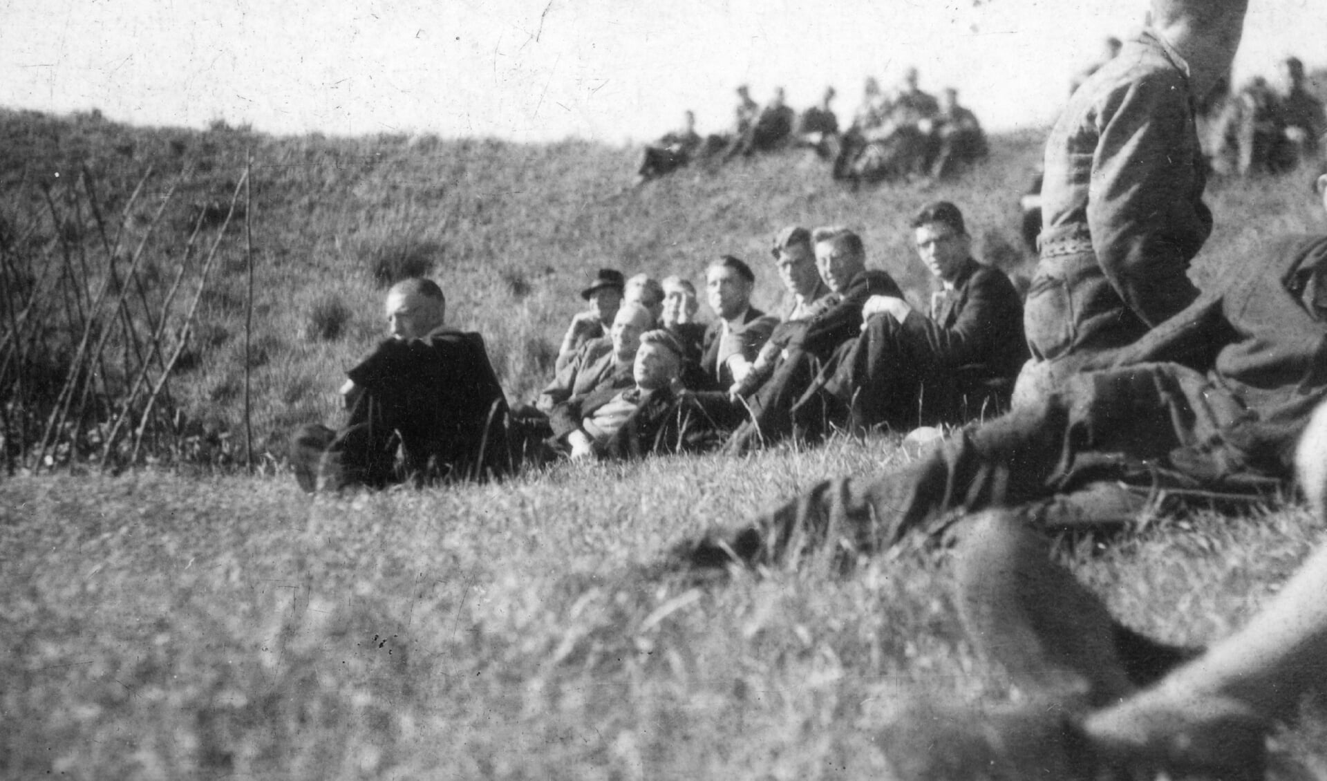 • Foto uit 1943. Luchtalarm gaat af bij Van der Giessen. De mannen zitten in het gras, ver van de werf in de polder. Het luchtalamr ging soms drie keer per dag af..
