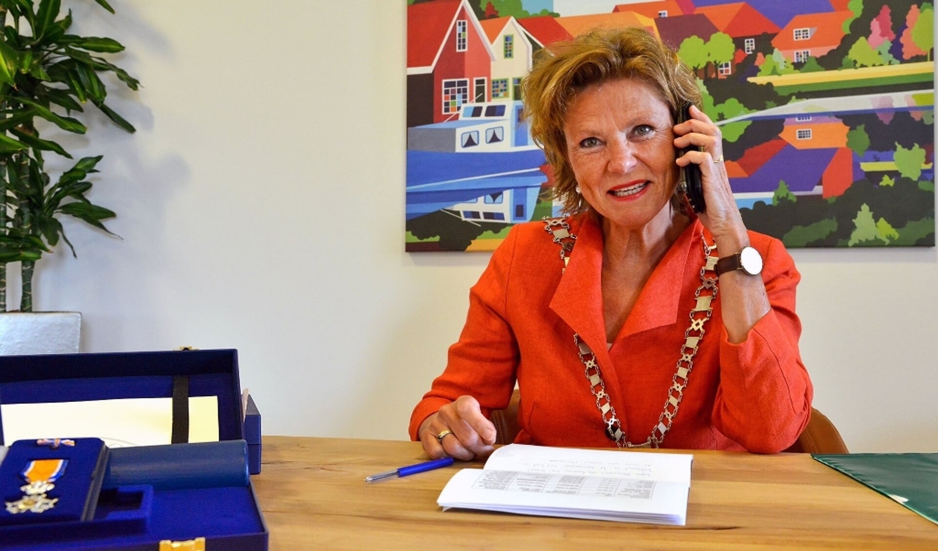 Burgemeester Petra van Hartskamp belt In verband met de coronacrisis de volledig verraste gedecoreerden.  (Foto: Paul van den Dungen)