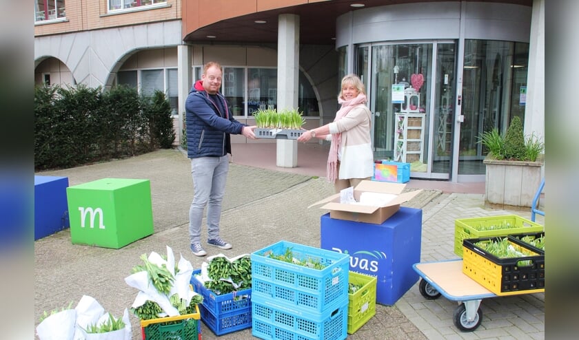 • Dennis de Heer overhandigt een bak bloemen aan Henny Tukker.