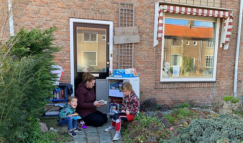 • Mirjam met haar stiefkinderen bij de mini bieb.