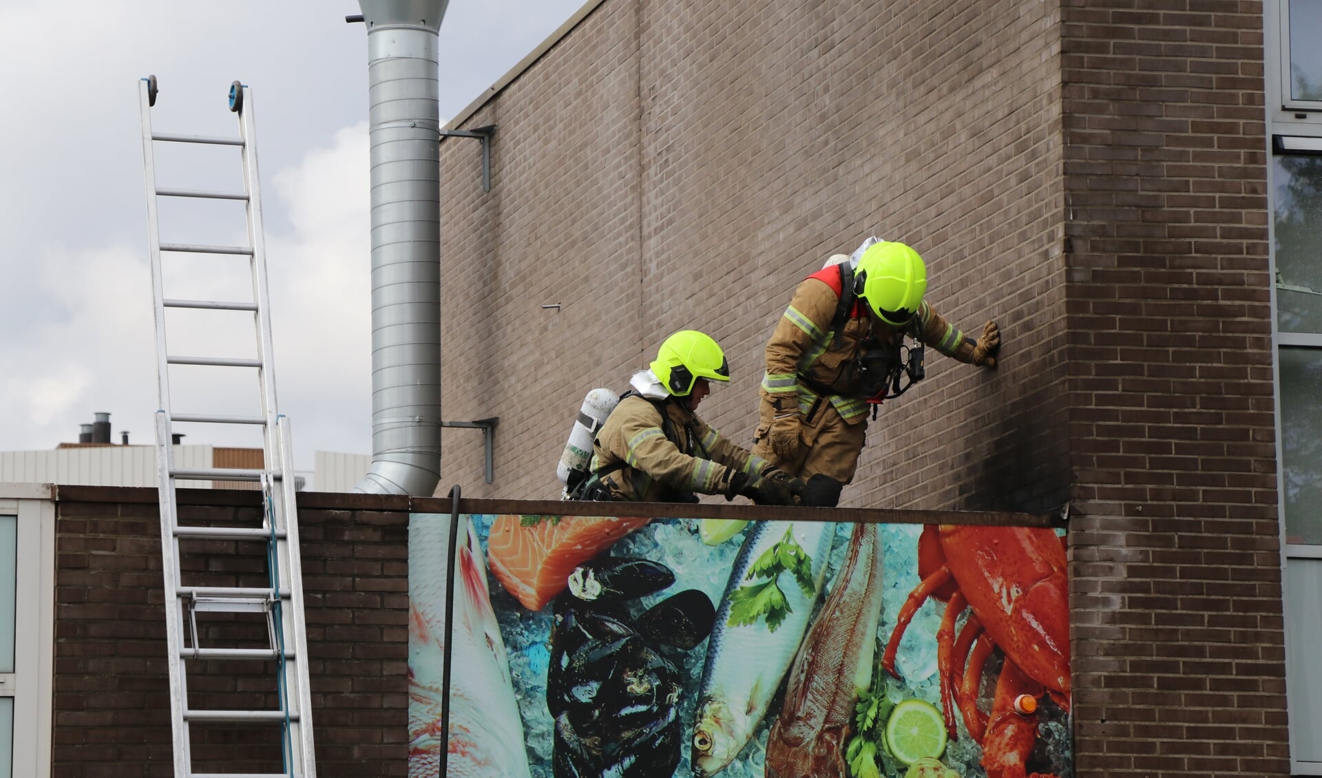 • Brandweerlieden op het dak van de winkel.