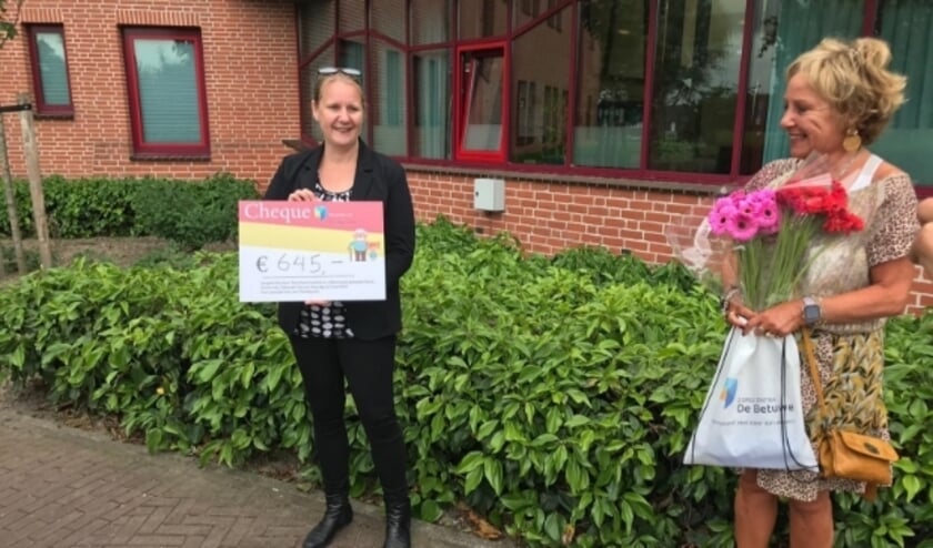 Medewerkers van Zorgcentra De Betuwe nemen cheque in ontvangst.
