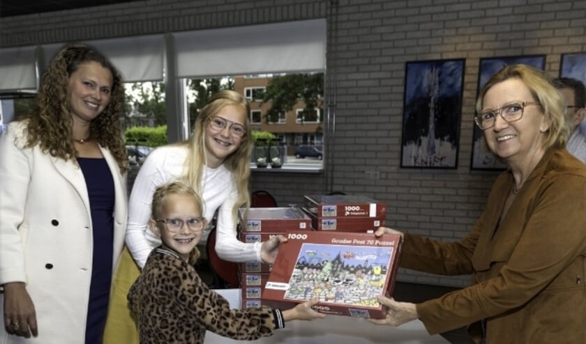 Mama Marja met dochters Anne-Lotte en Charlène krijgen de eerste Goudse Post puzzel uitgereikt door eindredacteur Marianka Peters.  Foto: Jan van den Berg  