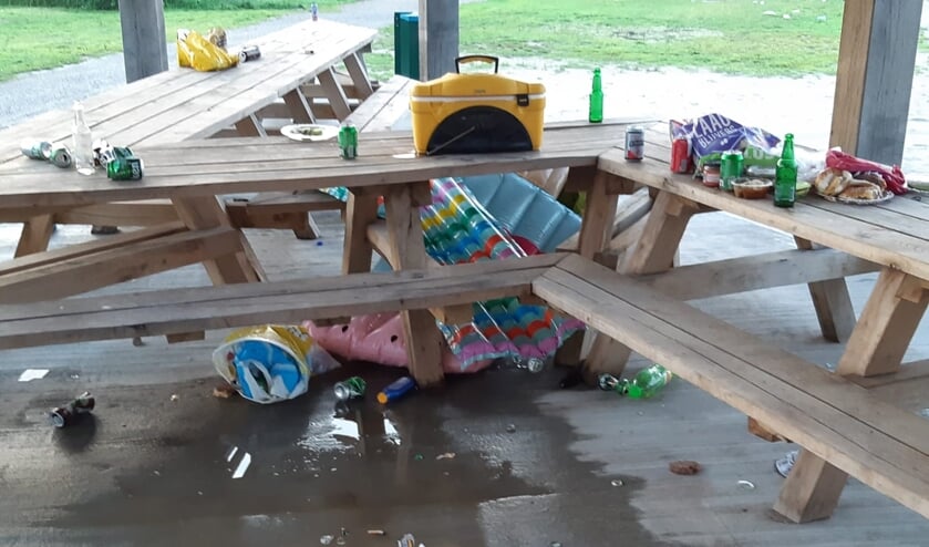 • Op en rond de houten tafels in het gebouw lag veel rommel.
