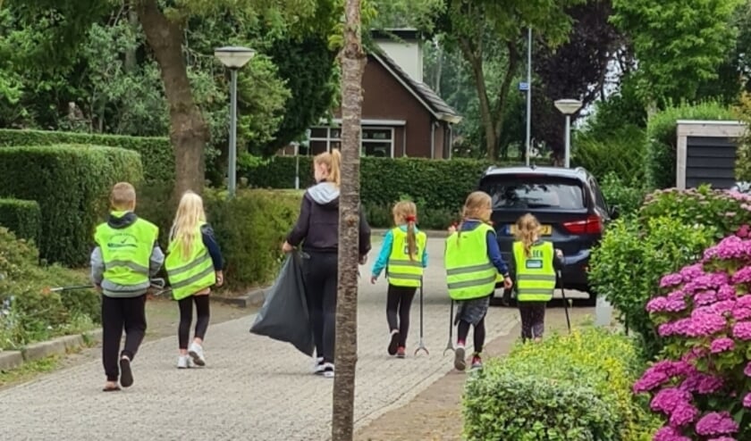 Kinderen van Basisschool De Hoge Hof ruimen afval op.  